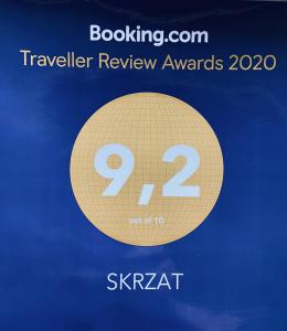 un cartel que dice "premios de revisión de viajes con un círculo de oro" en SKRZAT, en Tumlin