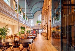 een restaurant met tafels en stoelen in een gebouw bij Bunk Hotel Utrecht in Utrecht