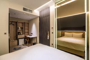 ein Schlafzimmer mit einem großen Bett und einem Schreibtisch in der Unterkunft The Quay Hotel in Singapur