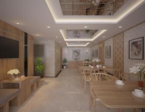 a restaurant with tables and chairs and a flat screen tv at Fukurai Hotel & Apartment 2 Ha Noi in Hanoi