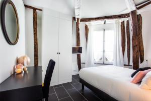 um quarto com uma cama, uma secretária e um espelho em CMG Rex - Bonne Nouvelle IV em Paris