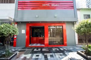 un hotelhen con una puerta roja en un edificio en Belém Hotel, en São Paulo