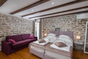 a bedroom with a bed and a purple couch at Awesome Stone House in Split +87 photos