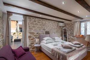 1 dormitorio con 1 cama grande y pared de piedra en Awesome Stone House, en Split