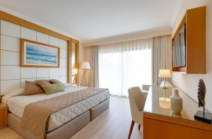 Una habitación de hotel con una cama y un escritorio y un escritorio. en PortAventura Hotel PortAventura - Includes unlimited access to PortAventura Park & 1 access to Ferrari Land, en Salou