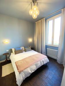 ミラノにあるCeruleo apartmentの大きなベッドとシャンデリアのある寝室