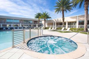 a swimming pool with palm trees and a building at Ramada by Wyndham Venice Hotel Venezia in Venice