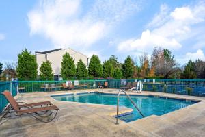 a swimming pool with a bench and a chair at La Quinta by Wyndham Florence in Florence