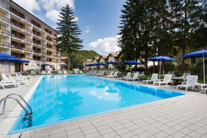 una piscina en un hotel con sillas y sombrillas en Grand Hotel del Parco, en Pescasseroli