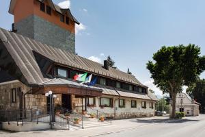 un bâtiment avec deux drapeaux au-dessus dans l'établissement Grand Hotel del Parco, à Pescasseroli