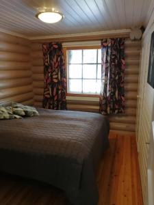 a bedroom with a bed and a window with curtains at Levihaukka 10 in Sirkka