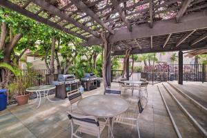 a patio with tables and chairs under a pergola at Kihei Condo with Resort Amenities Walk to the Beach in Wailea