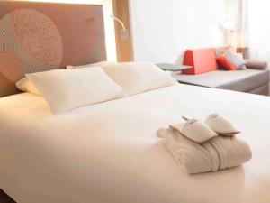 uma cama branca com duas toalhas dobráveis em Novotel Paris La Defense Esplanade em Courbevoie