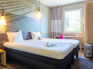 een hotelkamer met een groot bed en een raam bij ibis Deauville Centre in Deauville