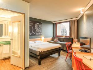 a hotel room with a bed, table and a lamp at Ibis Wien Mariahilf in Vienna