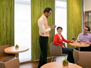 a man standing in a room with a woman at ibis Ulm City in Ulm