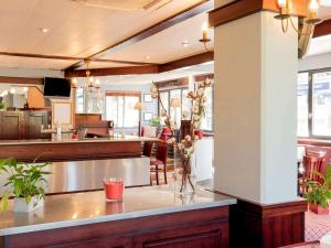 a kitchen with a counter and a dining room at ibis Lourdes Centre Gare in Lourdes