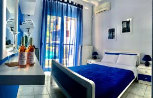 a bedroom with a bed and a table with bottles on it at Hotel Elena in Pyrgadikia