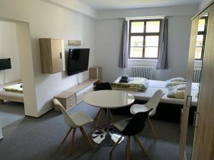 インドルジフーフ・フラデツにあるPenzion Měšťanのベッド、テーブル、椅子が備わる小さな客室です。