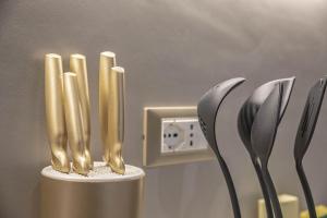 a group of gold candles on a holder with utensils at Villa Bonelli in Siena