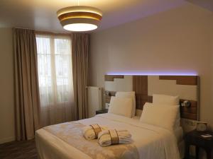 een slaapkamer met een groot wit bed en een licht bij Mercure Paris Opéra Faubourg Montmartre in Parijs
