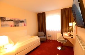 ein Hotelzimmer mit einem Bett und einem TV in der Unterkunft Hotel Montana in Diemelstadt 