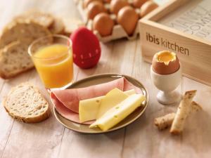 a table with a plate of cheese and eggs and bread at ibis Brugge Centrum in Bruges