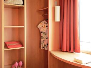 een kamer met een boekenplank en een raam bij Hotel Ibis Brugge Centrum in Brugge