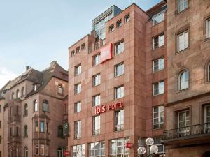 un edificio de ladrillo con un cartel de hotel de autobús. en ibis Hotel Nürnberg Altstadt, en Núremberg