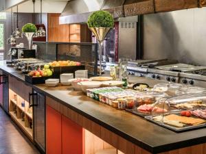 a kitchen with alot of food on a counter at Hôtel Mercure Lille Aéroport in Lesquin