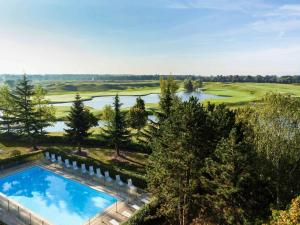 uma vista aérea de um campo de golfe com uma piscina em Novotel Saint-Quentin en Yvelines em Magny-les-Hameaux