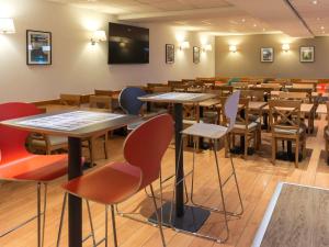 a room with tables and chairs in a classroom at ibis Liège Centre Opéra in Liège