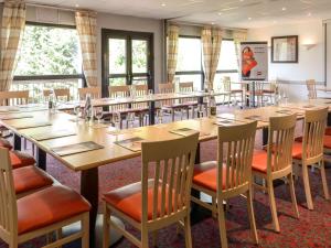 une salle de conférence avec une grande table et des chaises dans l'établissement Hôtel Ibis Nevers, à Nevers