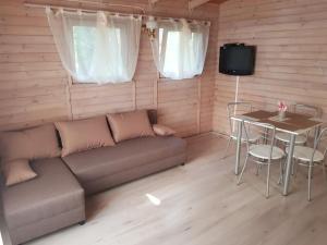 uma sala de estar com um sofá e uma mesa em Mazurska Sielanka na Wiartlu em Pisz