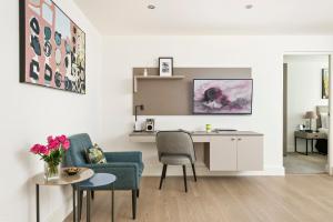 een woonkamer met een bureau, een stoel en een tafel bij The Chronicle by Supercity Aparthotels in Londen