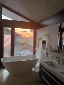 een badkamer met een groot bad en 2 wastafels bij Residence in Chieming