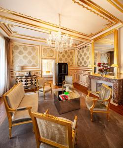 sala de estar con muebles y lámpara de araña. en Hotel Le Place d'Armes - Relais & Châteaux, en Luxemburgo