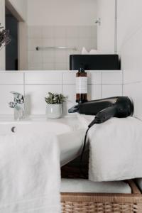 a white bathroom with a sink and a mirror at Hotel Esplanade in Gmunden