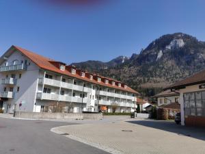 un grand immeuble avec une montagne en arrière-plan dans l'établissement Aschau-Apartments, à Aschau im Chiemgau