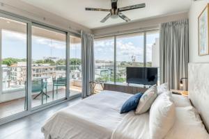 a bedroom with a large bed and large windows at Turchese 303 N @ The Gallery in Playa del Carmen