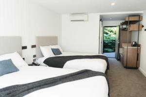 a hotel room with three beds and a kitchen at Kamana Lakehouse in Queenstown