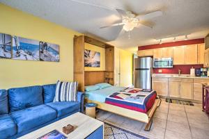 a living room with a blue couch and a kitchen at Kailua-Kona Studio - Walk to Hale Halawai Park! in Kailua-Kona