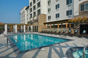 una piscina en un hotel con sillas y un edificio en Oxford Suites Sonoma - Rohnert Park, en Rohnert Park