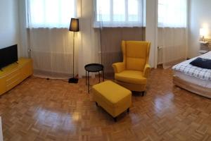 1 dormitorio con 1 cama, 1 silla y TV en HSH Barre 6 - City Apartment next Cathedral Lausanne en Lausana