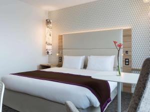 een hotelkamer met een groot bed en een tafel bij Mercure Paris Orly Rungis Aéroport in Rungis
