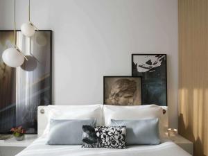 a bedroom with a bed with white sheets and pillows at Sofitel Roma Villa Borghese in Rome