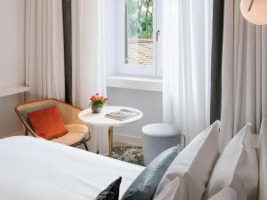 a room with a bed and a table and a window at Sofitel Roma Villa Borghese in Rome