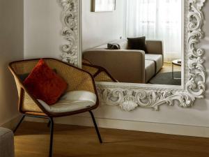 a living room with a chair and a mirror at Sofitel Roma Villa Borghese in Rome