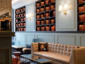 - un canapé en cuir dans une pièce avec des livres dans l'établissement Hotel Rotary Geneva - MGallery, à Genève