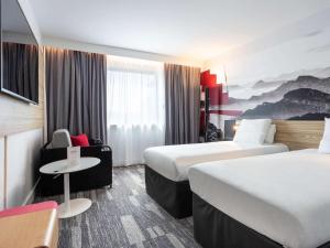 Habitación de hotel con 2 camas y mesa en Novotel Annecy Centre, en Annecy